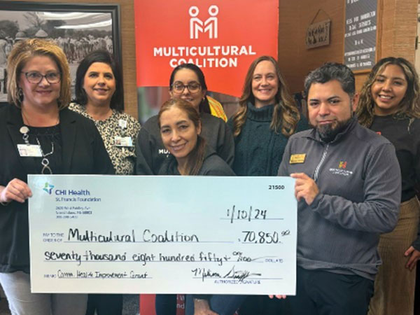 Kiley Grzywa, (left) vice president of patient care services, CHI Health St. Francis and Melissa Griffith, (second from left) director, CHI Health St. Francis Foundation presented a Community Health Improvement Grant check for $70,850 to the Multicultural