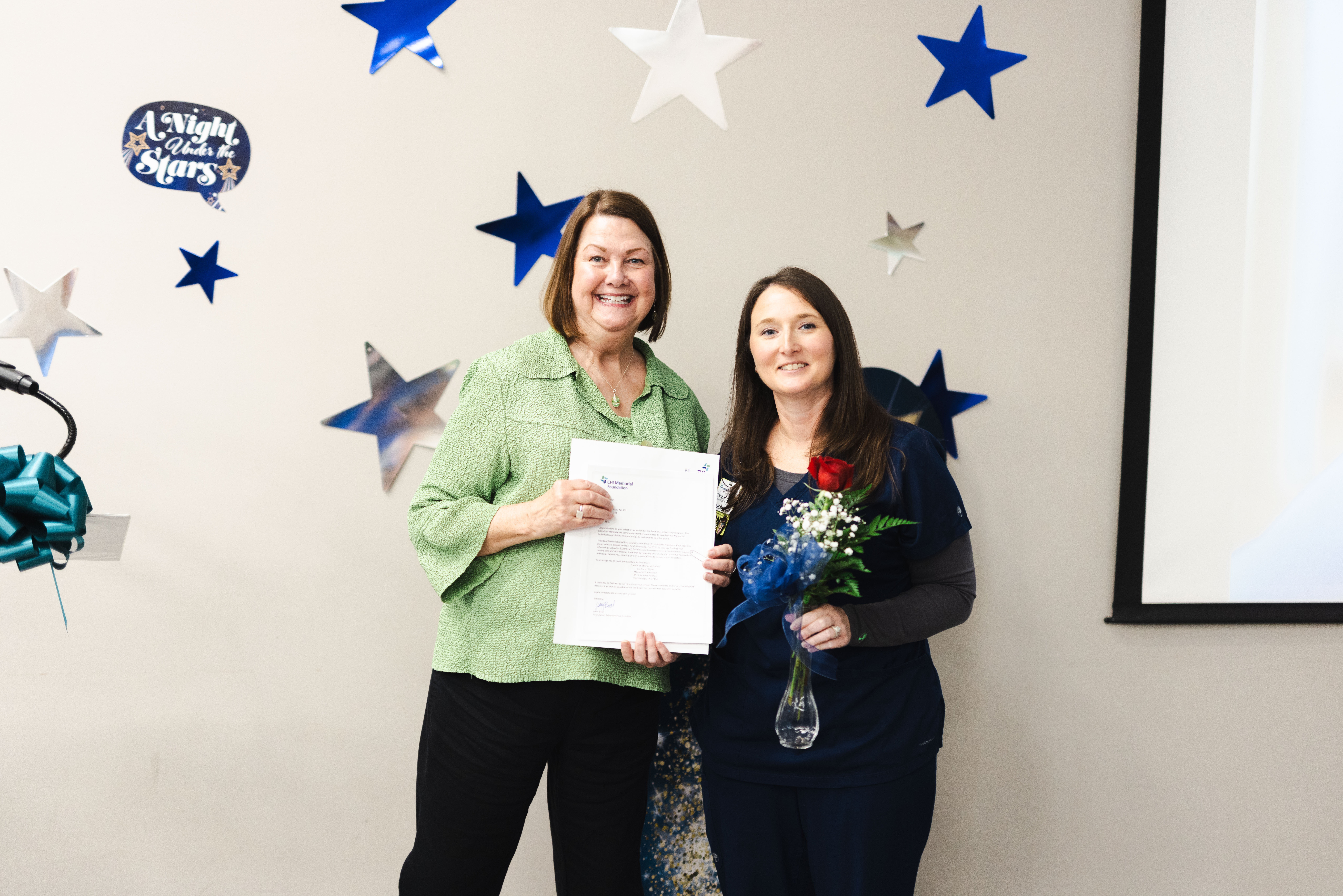 two women holding a certificate
