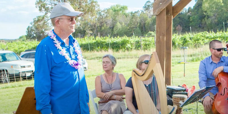 Roy Cook on stage at the Philly awards in an outdoor ceremony, a harp and cello in the background