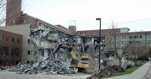 The demolition of old St Anthony's Hospital showing wrecking equipment tearing away at a brick wall