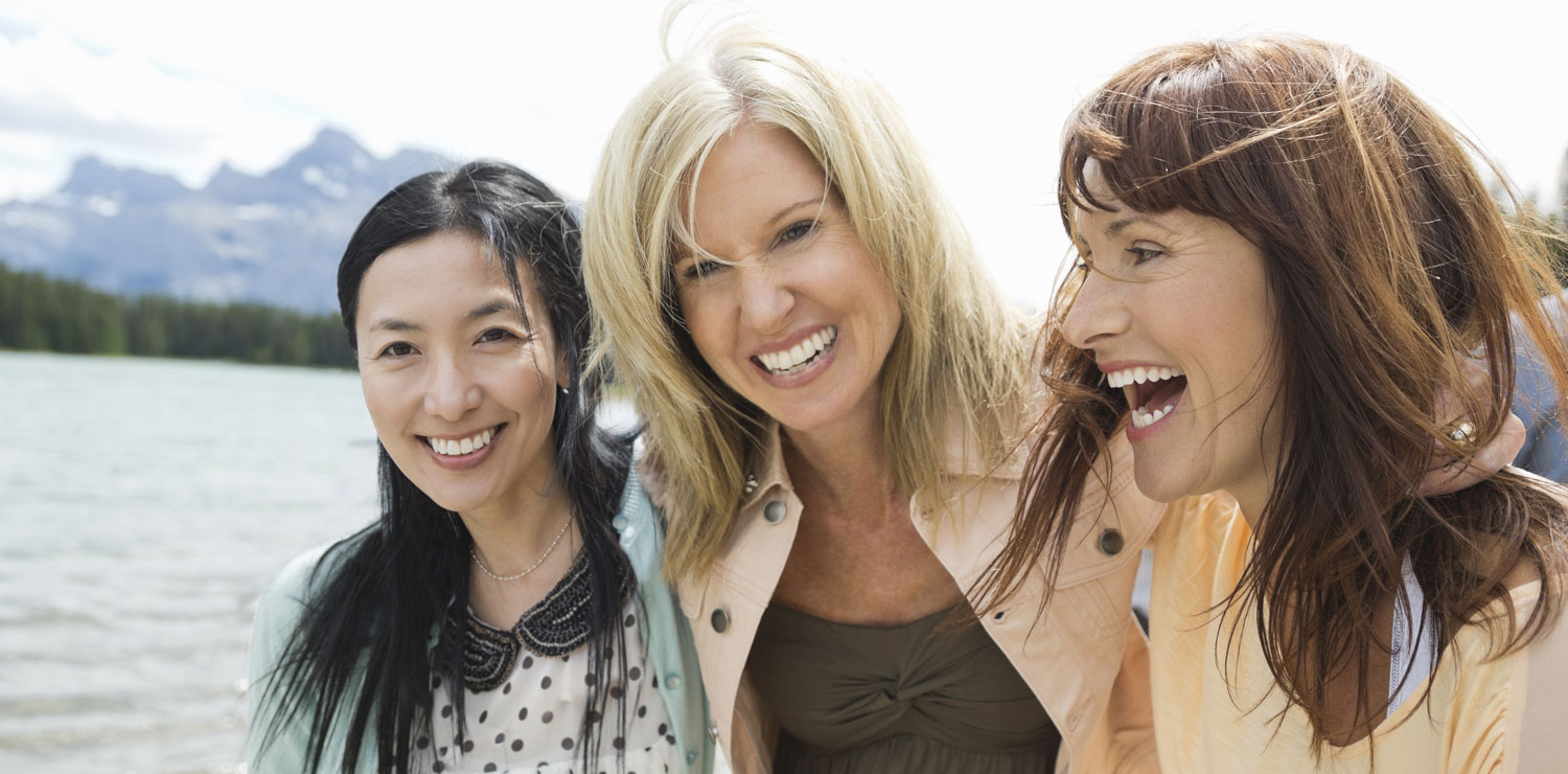 Three senior women laughing in mountains