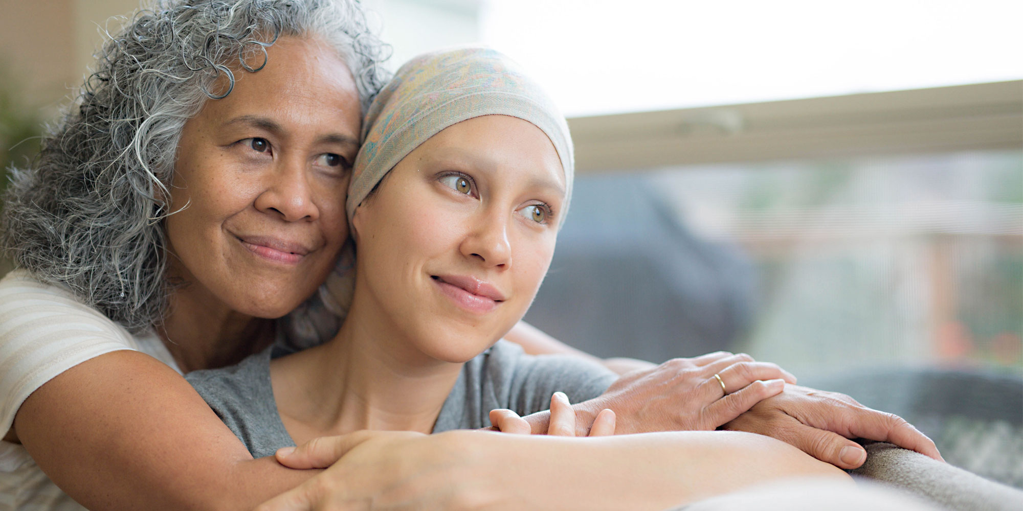 Mom hugging daughter with cancer