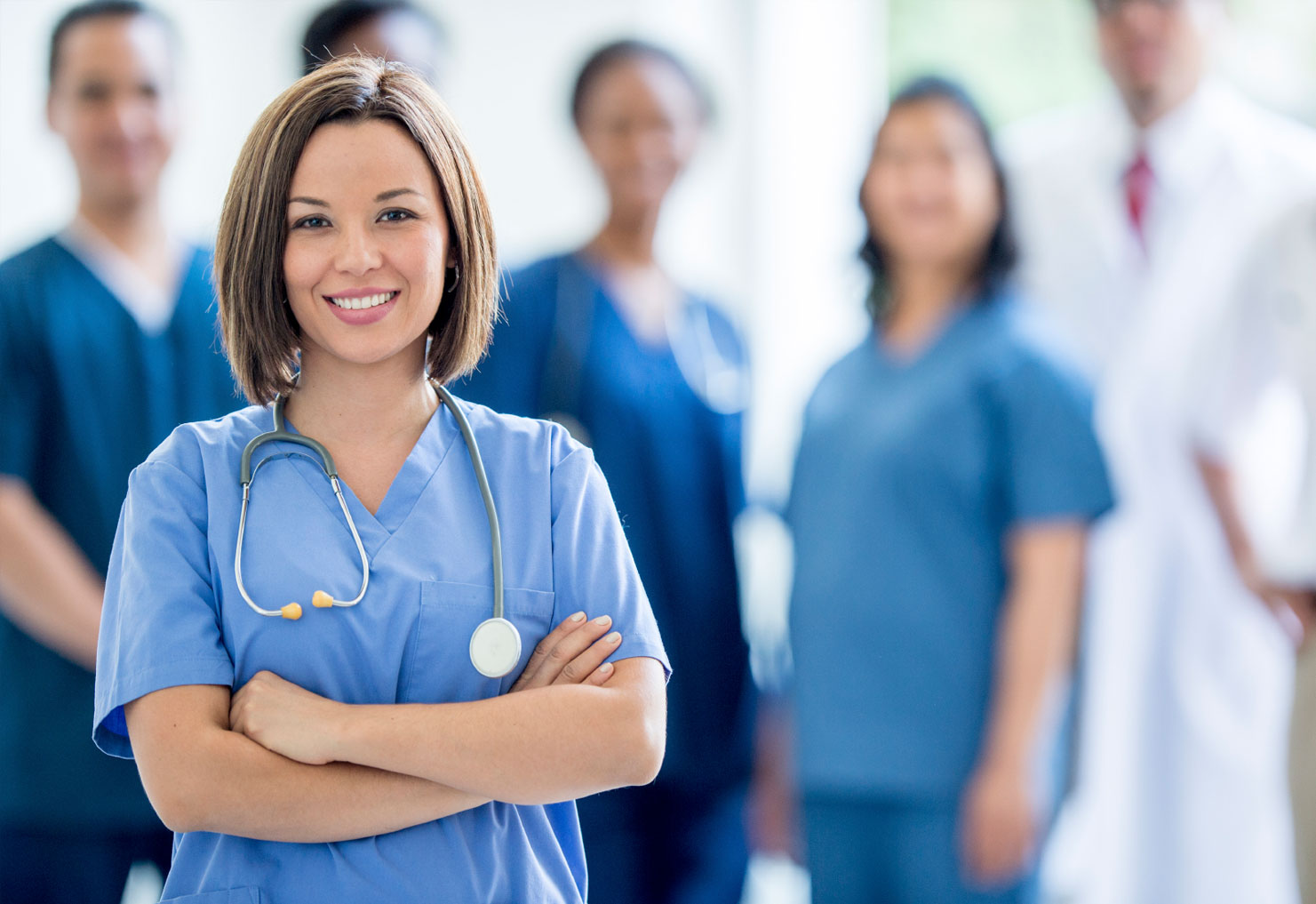 Female provider looking at camera with other providers in the background.